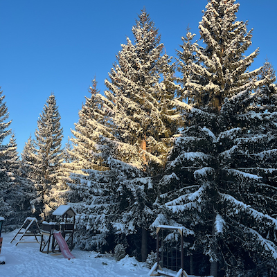 Snow-covered playground with swing set in winter sunlight Baisoara